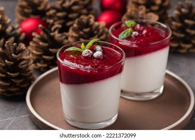 Vegan Dairy Free Coconut Panna Cotta With Cranberry Sauce In Glasses On A Dark Stone Table. Healthy Dessert. Christmas And New Year's Composition With Red Christmas Balls, Pine Cones.