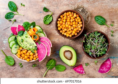Vegan, detox Buddha bowl recipe with avocado, carrots, spinach, chickpeas and radishes. Top view, flat lay, copy space 