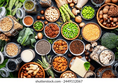 Vegan food background. Plant protein., vegetarian nutrition sources. Healthy eating, diet ingredients: legumes, beans, lentils, nuts, soy milk, tofu, cereals, seeds and sprouts. Top view, black table - Powered by Shutterstock