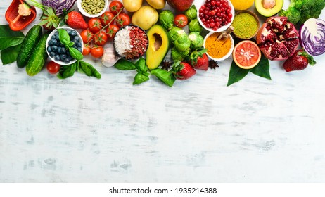 Vegan food banner. Fresh vegetables and fruits and berries on a white wooden background. Free space for your text.