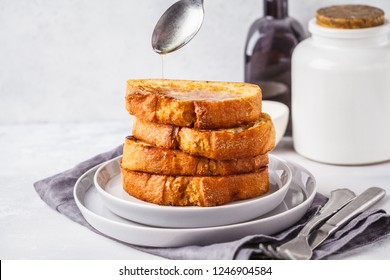 Vegan french toasts with syrup on a gray plate.