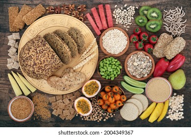 Vegan health food very high in dietary fibre with fruit, vegetables, nuts, seeds, legumes, cereals  grain products. Immune boosting healthy foods on rustic wood background. Flat lay. Top view. - Powered by Shutterstock