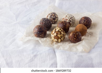 Vegan Healthy Energy Balls With Oatmeal, Chia Seed, Coconut Flakes, Cocoa, Dried Fruits And Almond. No Cook Energy Bites On Baking Paper.