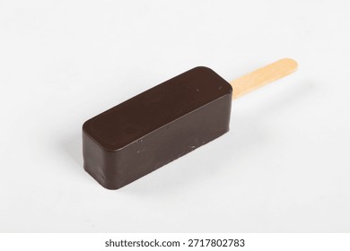 Vegan ice cream is rectangular in shape. In dark chocolate glaze. On a wooden stick. White background. Close-up.