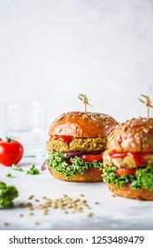 Vegan lentil burgers with kale and tomato sauce on a white background. Plant based food concept. - Shutterstock ID 1253489479