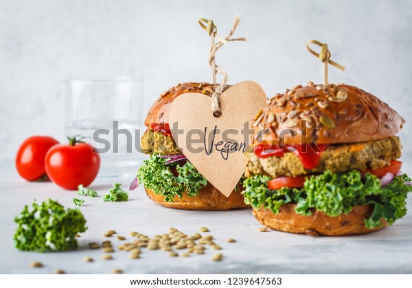 Vegan lentil burgers with kale\
and tomato sauce on a white background. Plant based food\
concept.