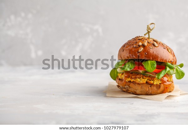 Vegan lentils burger with
vegetables and curry sauce. Light background, copy space. Vegan
food concept.