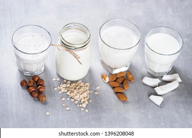 Vegan Non Dairy Alternative Milk. Coconut, Almond, Hazelnut, Oat Homemade Milk On Stone Table. Top View With Copy Space.