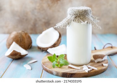 Vegan non dairy alternative milk, health content. Organic coconut milk in a bottle on a rustic table.