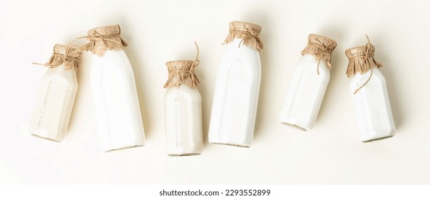Vegan non dairy plant based milk in bottles on light background banner. Alternative lactose free milk substitute. Top view - Shutterstock ID 2293552899