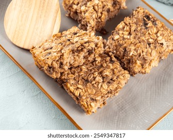 Vegan oatmeal banana cake bars on gray dish. Healthy breakfast baked porridge bars with rolled oats, banana, peanut butter, soy milk and chocolate chips - Powered by Shutterstock