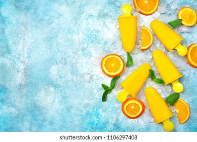 Vegan orange popsicles on an ice cubes over light blue slate, stone or concrete background.Top view with copy space. - Shutterstock ID 1106297408