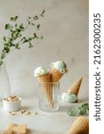 Vegan pistachio ice cream made with real pistachios and coconut milk in the horn decorated with daisies. Summer seasonal cold sweet healthy vegan dessert. High quality photo