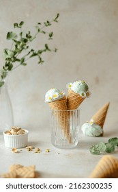 Vegan pistachio ice cream made with real pistachios and coconut milk in the horn decorated with daisies. Summer seasonal cold sweet healthy vegan dessert. High quality photo