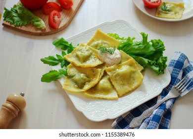 Vegan ravioli with fresh green herbs filling and tofu sauce in a white plate. Italian cuisine