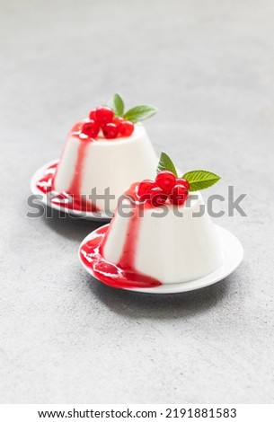 Vegan Red currant cream dessert, Panna Cotta with sauce, on a plate. Light gray background
