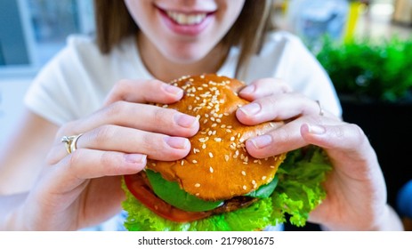 Vegan sandwich healthy vegetarian burger. Cute cheerful girl eating veggie hamburger with salad, avocado, vegetable. Vegetarian diet food concept - Shutterstock ID 2179801675