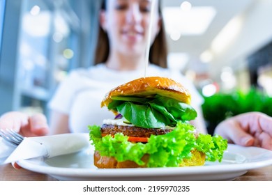 Vegan Sandwich Healthy Vegetarian Burger. Cute Cheerful Girl Eating Veggie Hamburger With Salad, Avocado, Vegetable. Vegetarian Diet Food Concept