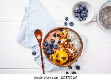 Vegan Smoothie Bowl With Chia Pudding, Berries And Granola In Coconut Shell On White Background, Top View, Copy Space. Plant Based Diet Concept.