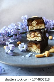 Vegan Snickers Bars On Grey Plate With Violet Flowers