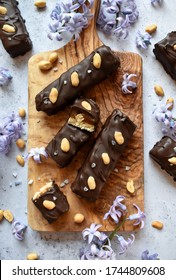 Vegan Snickers Bars With Peanut And Viole Flowers On Wood