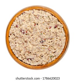 Vegan spread in a wooden bowl. Made of smoked tofu, kidney beans, roasted onions, herbs, salt and pepper. Paste that can be spread with a knife onto bread or crackers. Close-up from above, food photo.