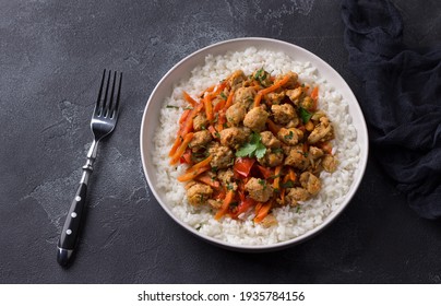 Vegan Stew Soy Meat And Vegetables Served With Boiled Rice And Greens On Black Textured Background. Delicious Healthy Diet Food