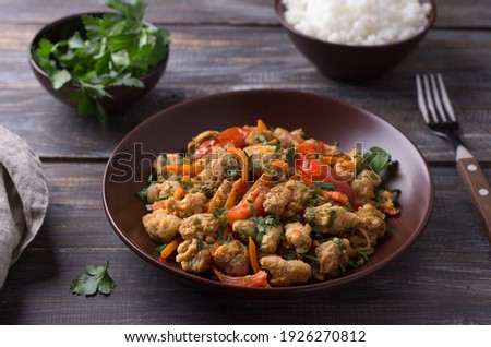 Vegan stew soy meat and vegetables served with boiled rice and herbs on a wooden table, selective focus, horizontal. Delicious healthy diet food