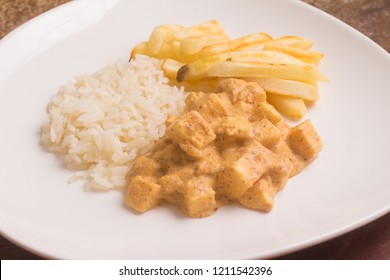 Vegan Stroganoff with Palm Heart,  rice and fries over a wooden table