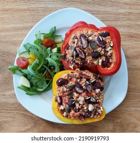 Vegan Stuffed Peppers With Millet, Kiney Beans, Nuts, Seeds And Salad On A Plate