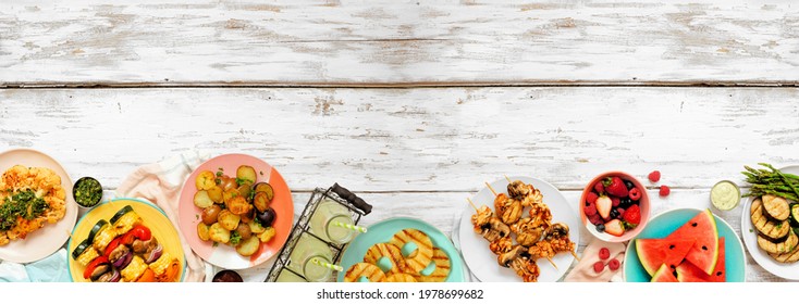 Vegan summer bbq or picnic bottom border. Top view on a white wood banner background. Fruit, grilled vegetables, skewers, cauliflower steak and lemonade. Copy space. Meat substitute concept.