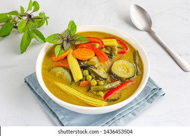 Vegan Thai Green Curry With Zucchini, Carrots, Baby Corn And Green Peas, Garnished With Thai Basil, Directly Above Photo. Traditional Thai Food Photography