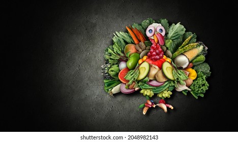 Vegan thanksgiving turkey and funny vegetarian autumn harvest symbol as vegetables fruit nuts and berries shaped as a festive gobbler for a holiday celebration on a black background as a composite.