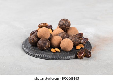 Vegan truffles made of dates, almonds and cocoa on a metal tray on a light gray background - Shutterstock ID 1901669185