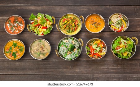 Vegan or vegetarian restaurant dishes top view, hot spicy indian soups, rice and salads in copper bowls. Traditional indian cuisine meal assortment on wood background. Healthy eastern local food - Shutterstock ID 516747673