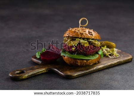 Vege burgers with carrots, beetroots and mushrooms. Front view. Black background.