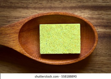 Vegetable Bouillon, Stock Or Broth Cube On Wooden Spoon, Photographed Overhead With Natural Light (Selective Focus, Focus On The Top Surface Of The Cube)