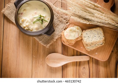 A Vegetable Chowder Prepared With Corn, And Carrot. Cracker Is Topped By Chowder Put On Wood.