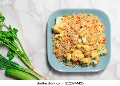 Vegetable Fried Rice With Cauliflower Carrot Egg In Blue Plate Isolated On White Background Close Up Has Spoon, Top View, Healthy Food Concept.