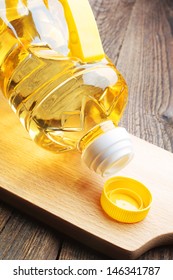 Vegetable oil in plastic bottle closeup on a cutting board
