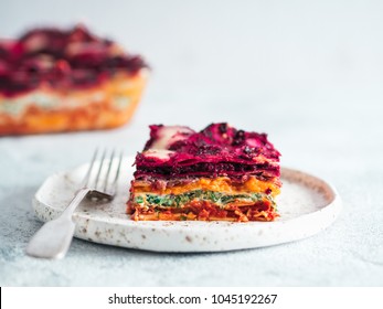 Vegetable Packed Rainbow Lasagne on craft plate.Ideas and recipes for healthy vegetarian dinner or lunch. Lasagne with beetroot,pumpkin,mushrooms,ricotta,spinach,mozarella on white table. Copy space