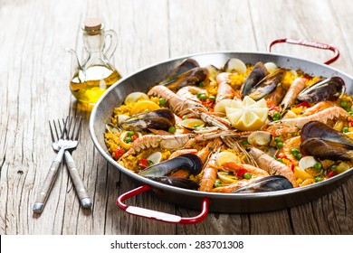 Vegetable paella with seafood on a wooden background