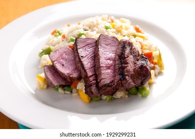 Vegetable Risotto With Rare Beef Tenderloin Grilled To Perfection And Sliced