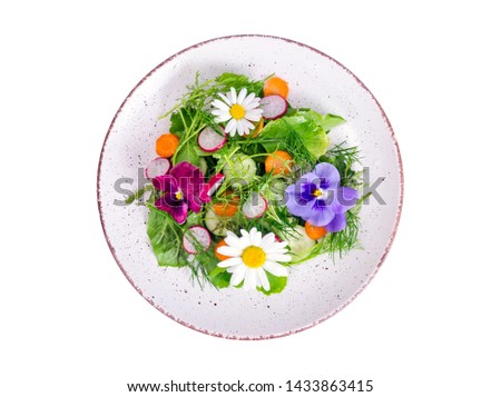 Vegetable salad with edible flowers on white background. Studio Photo