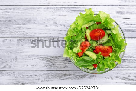 Vegetable salad in glass bowl on wooden table