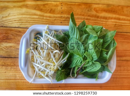 Vegetable Set (Mint leaves and ิean sprouts) on the white dish and wooden table
