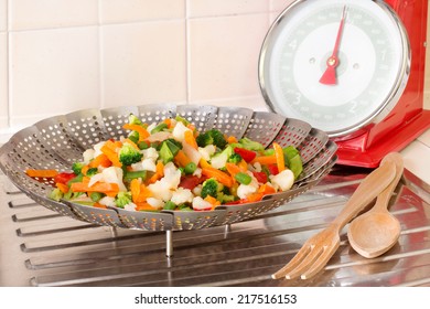 Vegetable Steamer With Vegetables MIX INSIDE AND BALANCE OVER DRAINING BOARD