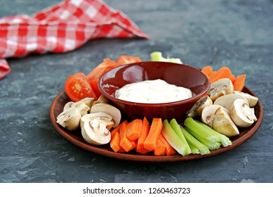 Vegetable Tray With A Ranch Dip On A Dark Background. Raw Vegetable Mix Includes Sliced Mushrooms, Carrots, Celery, Tomatoes.