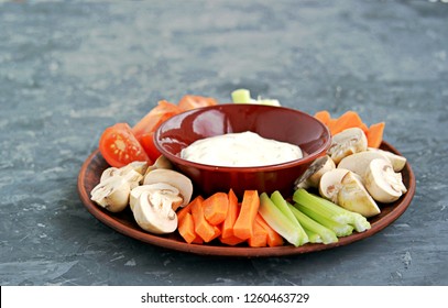 Vegetable Tray With A Ranch Dip On A Dark Background. Raw Vegetable Mix Includes Sliced Mushrooms, Carrots, Celery, Tomatoes.