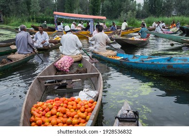  vegetable vendors sell their produce on their boat at  morning floating vegetable market - Dal Lake, Sri Nagar, India on 22 JULY 2018